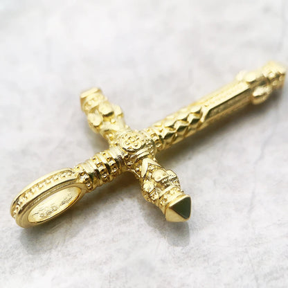 Goldener Kreuz-Anhänger in schräger Ansicht, Totenkopf-Relief und dunkle Einlagen an den Enden