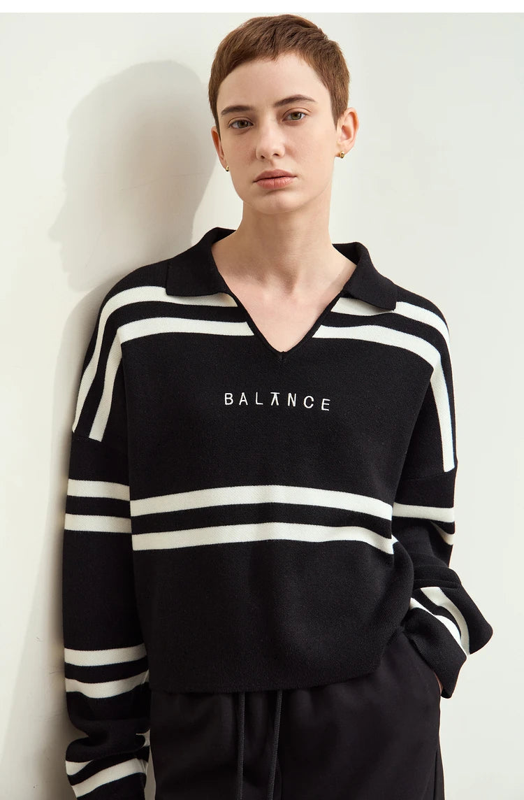 Schwarzer Pullover mit Streifen an den Ärmeln und Schriftzug „BALANCE“