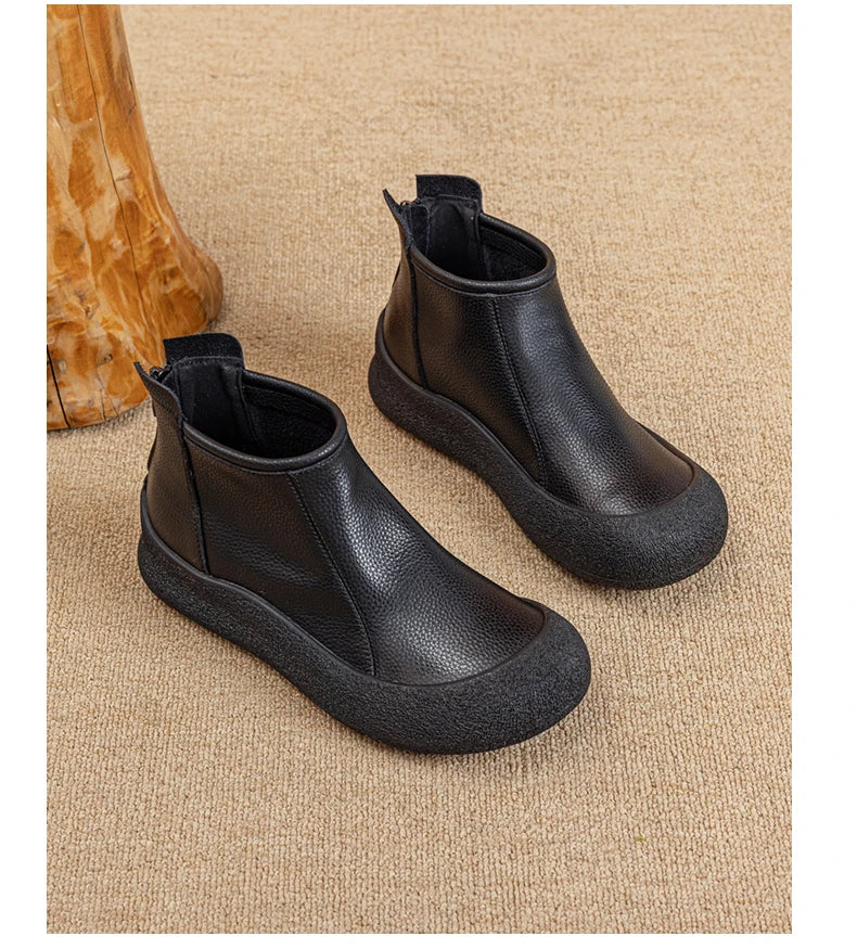 Schwarze flache Leder-Stiefeletten, gepolsterter Schaft, Rundkappe, seitlicher Reißverschluss.