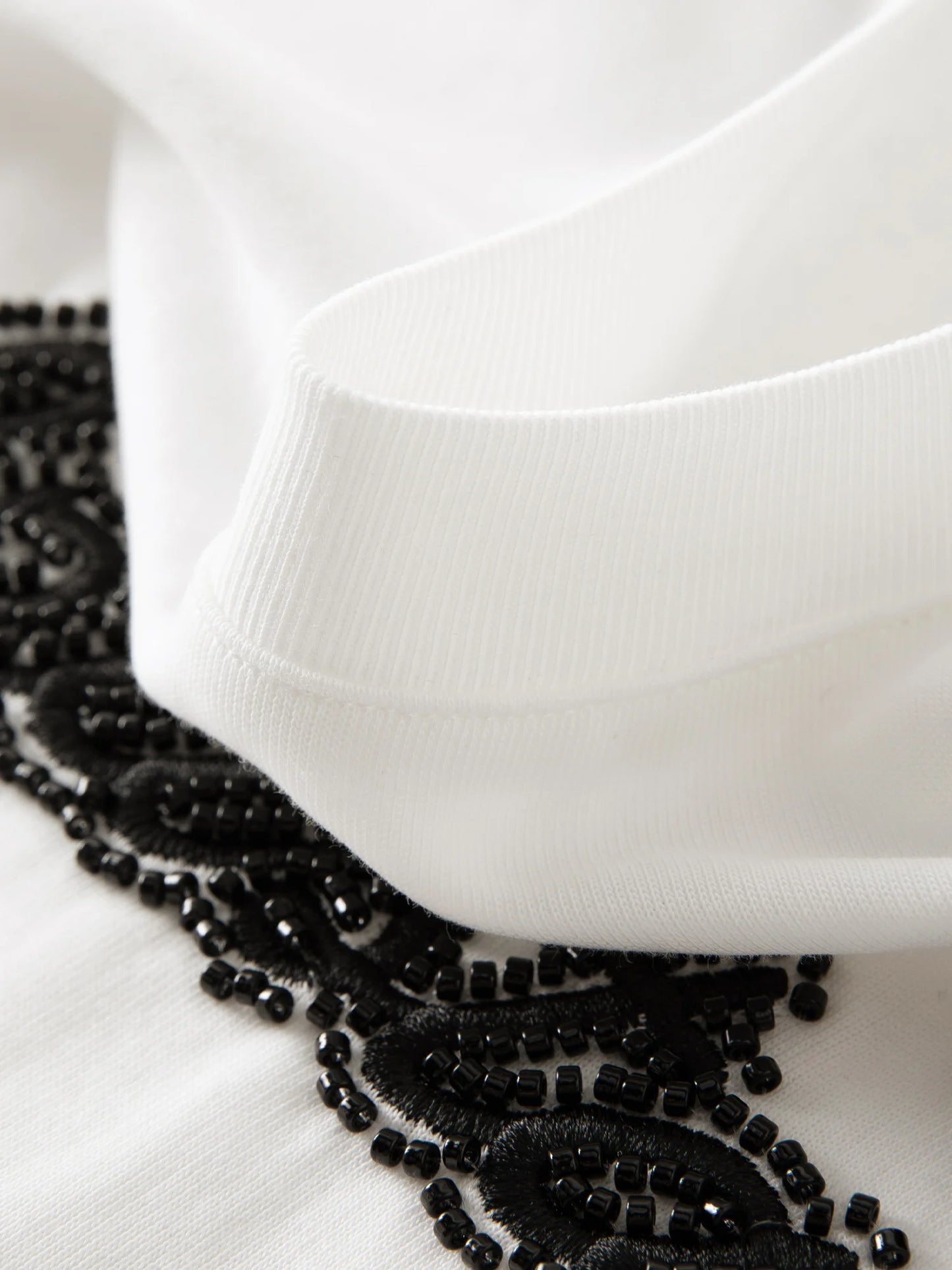 Damen T-Shirt mit V-Ausschnitt und strukturierten Schultern im Retro-Twist-Knotendesign für eine schlanke Silhouette