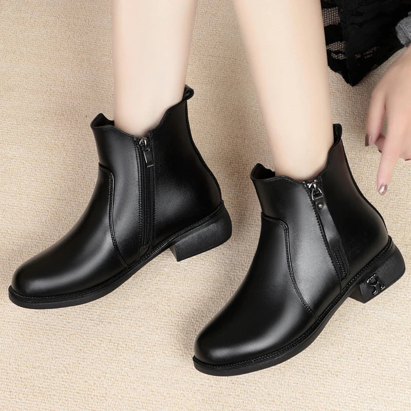 Schwarze Stiefelette am Fuß mit seitlichem Reißverschluss und kurzem Blockabsatz.