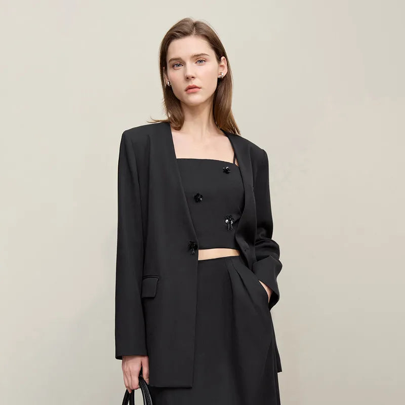 Schwarzer Damen-Blazer mit Knopfleiste, Brusttaschen und langen Ärmeln, über schwarzem Top