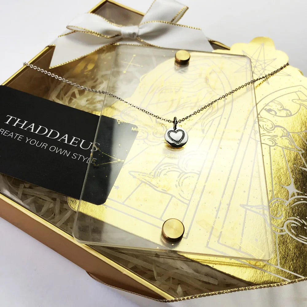 Herz-Anhänger auf goldfarbenem Geschenk-Set, runde silberne Scheibe an feiner Kette