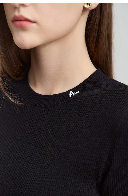 Nahaufnahme: Schwarzer Damen-Strickpullover mit Rundhalsausschnitt und Logo-Stickerei am Kragen