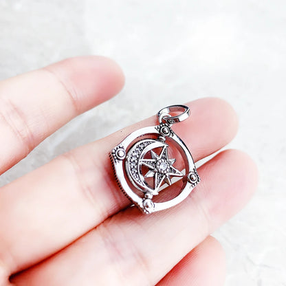 Stern-Mond-Anhänger aus 925er Sterlingsilber in der Hand, rundes Motiv mit Strahlenstern.