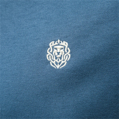 Detailaufnahme: gesticktes Brustlogo auf blauem Stoff des Herren-T-Shirts.