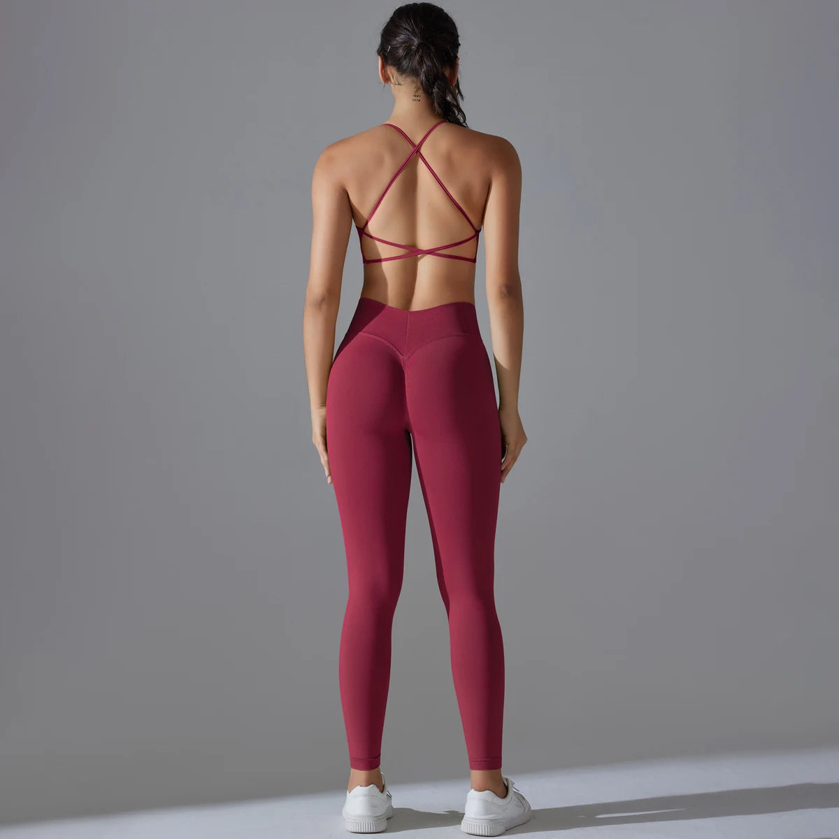 Nahtloses Yoga-Set in weinrot: Rückansicht mit gekreuzten Trägern am Sport-BH und Leggings