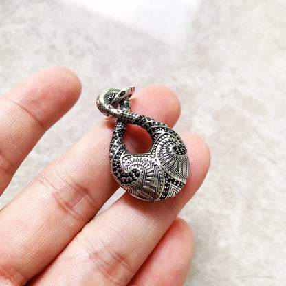 Anhänger aus 925er Sterlingsilber mit Maori-Endlos-Tattoo, in Hand gehalten