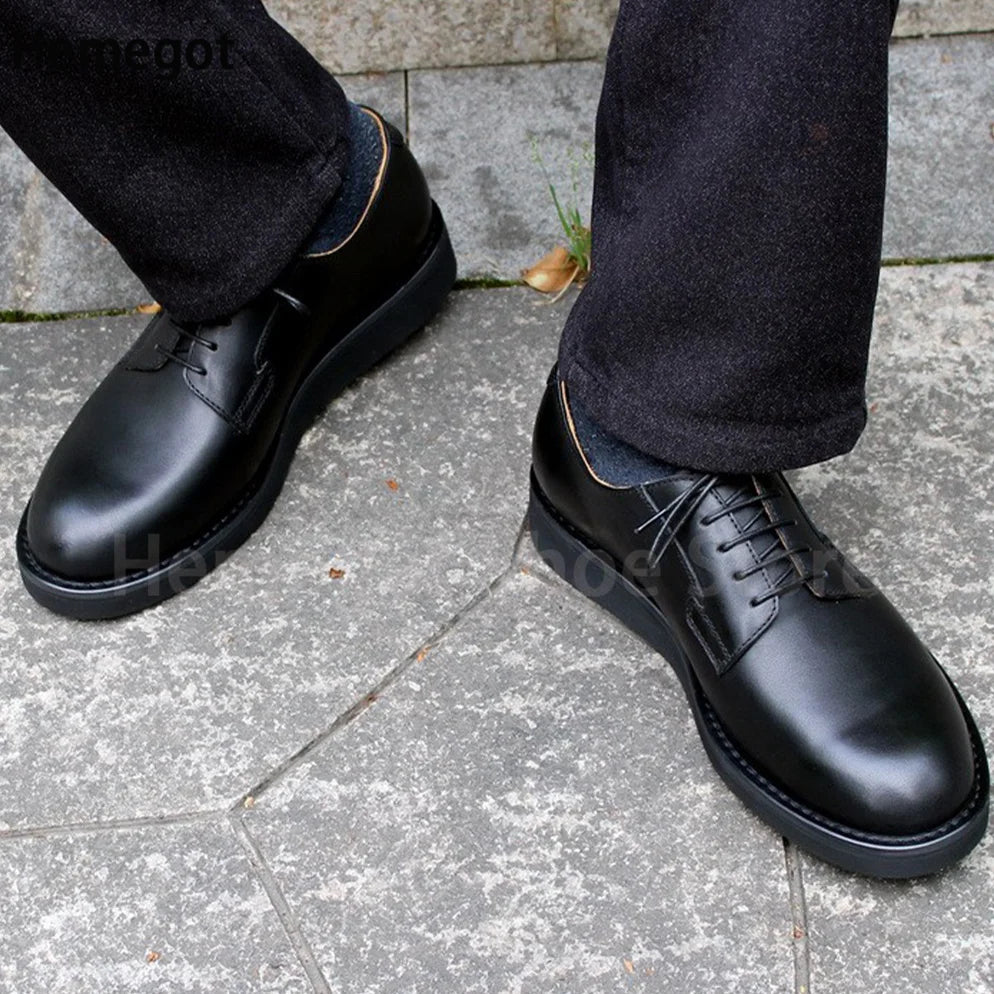 Schwarze Lederschnürschuhe für Herren, am Fuß getragen auf Gehweg