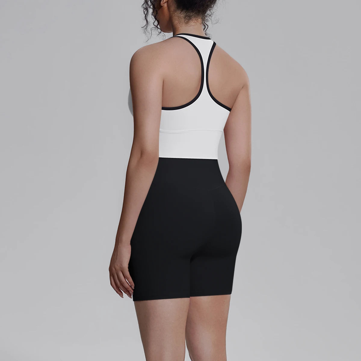 Yoga-Set für Damen von hinten: weißes Top mit schwarzem Rand, schwarze Shorts