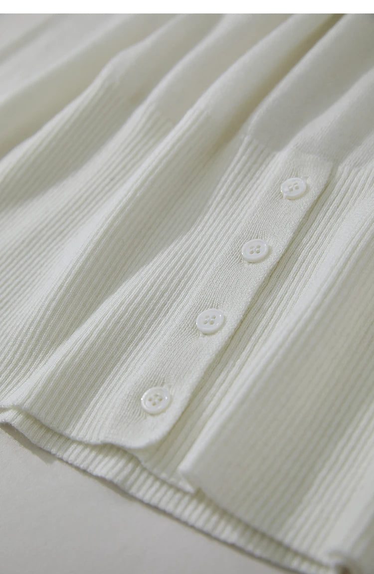 Detail vom unteren Saum: Weißer Damenpullover mit Knopfleiste aus Strick