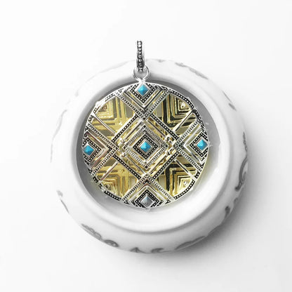 Vorderansicht: runder Anhänger mit goldfarbenem Mosaik-Design und blauen Schmuckeinsätzen