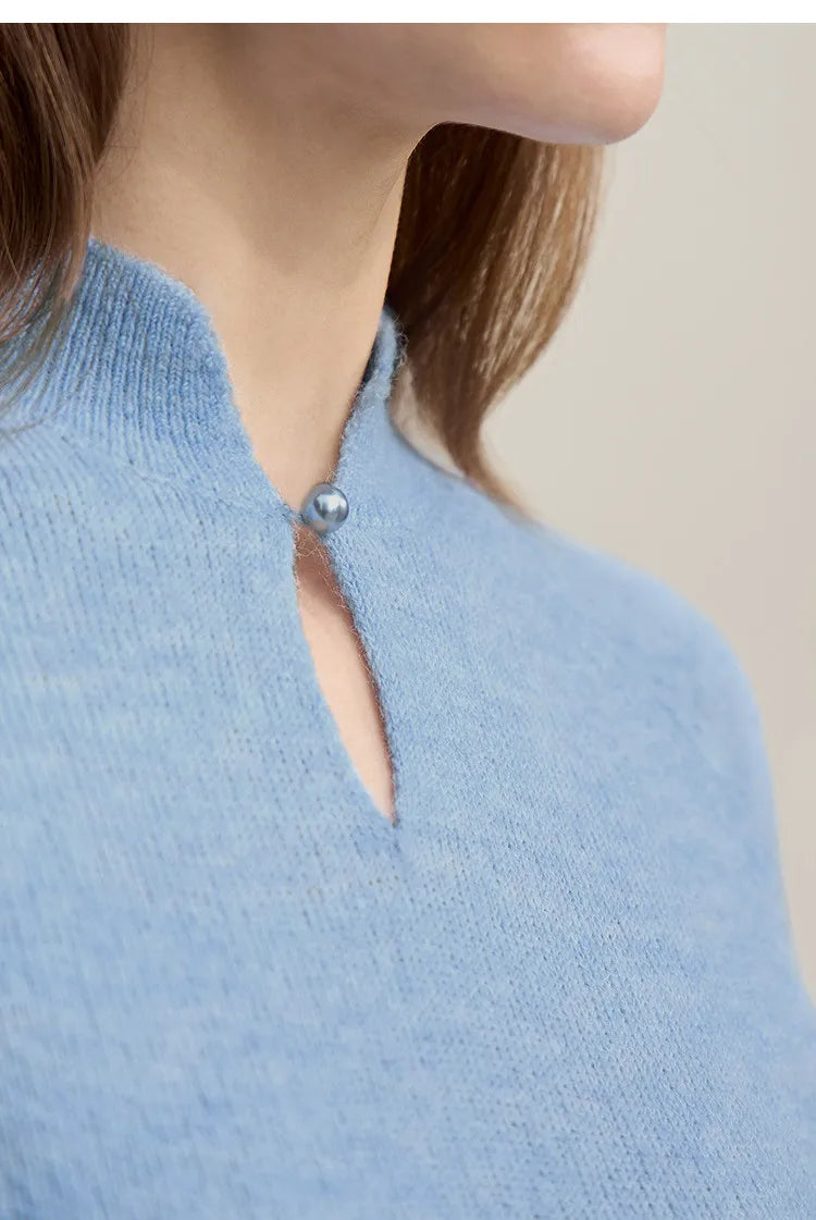 Heller blauer Wollpullover mit Stehkragen, Knopf und Cut-Out am vorderen Ausschnitt.