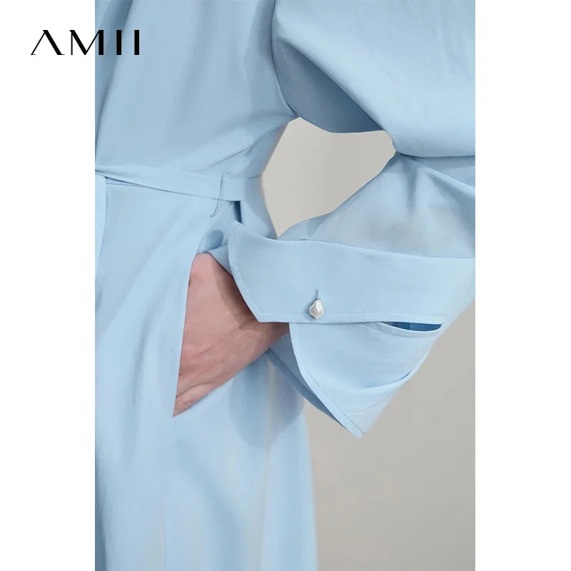 Hellblaues Damenkleid im Detail: Taillengürtel, Knopfleiste am Ärmel und V-Ausschnitt.
