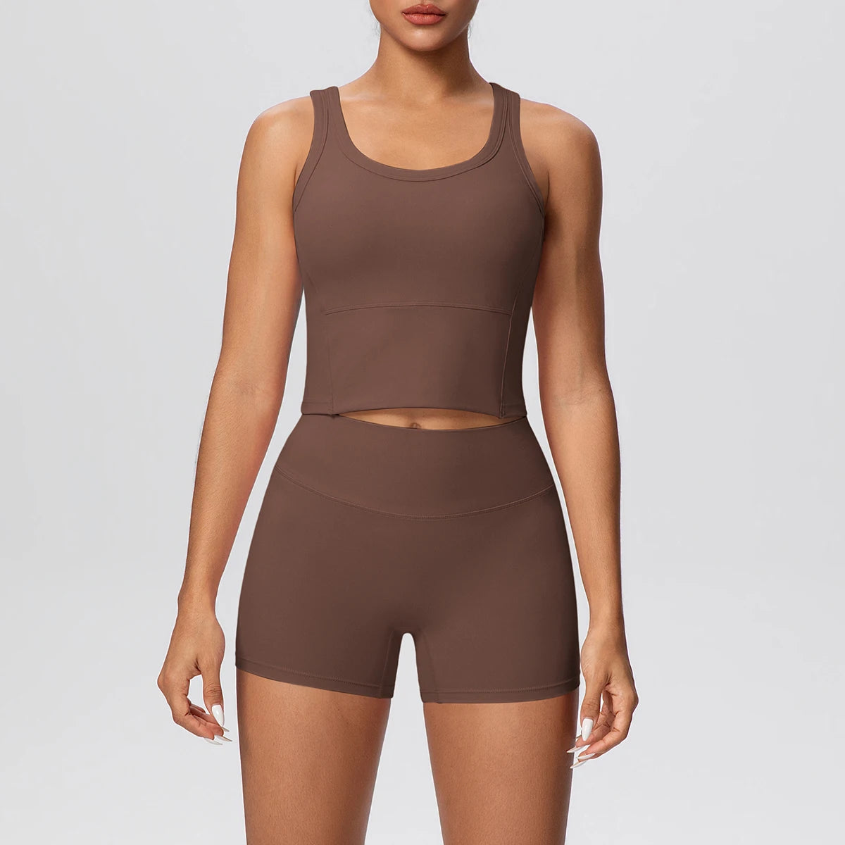 Damen-Yoga-Set in Braun: ärmelloses Croptop und kurze Leggings mit Midriff-Ausschnitt.